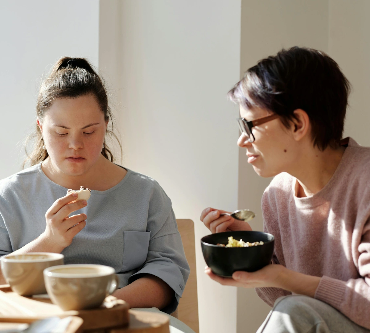 Disabled woman with down syndrome having lunch with friend