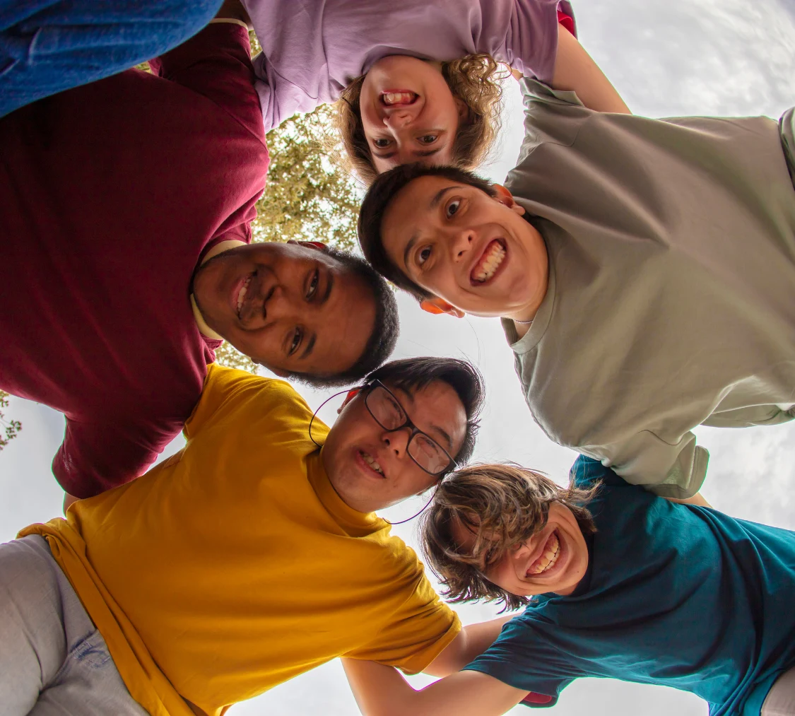 Group of diverse friends in circle looking at camera