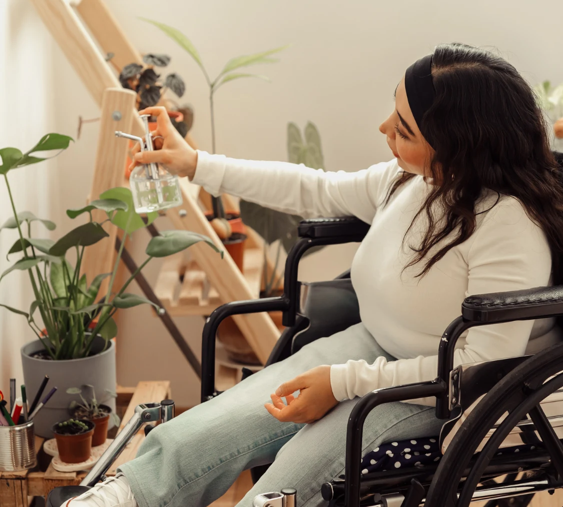 Disabled woman at home watering plants