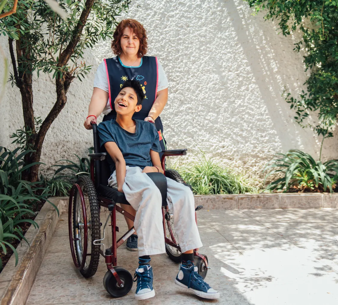 Disabled boy in wheelchair with carer